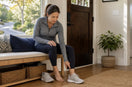 Woman noticing knee discomfort after returning home from a neighborhood walk