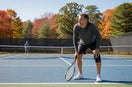 Middle-aged recreational tennis player noticing knee soreness during a fall match