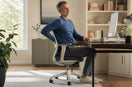 Adult seated at a desk with the knee bent around 90 degrees
